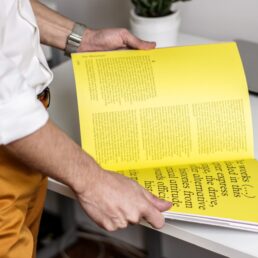 a man flips through a yellow book
